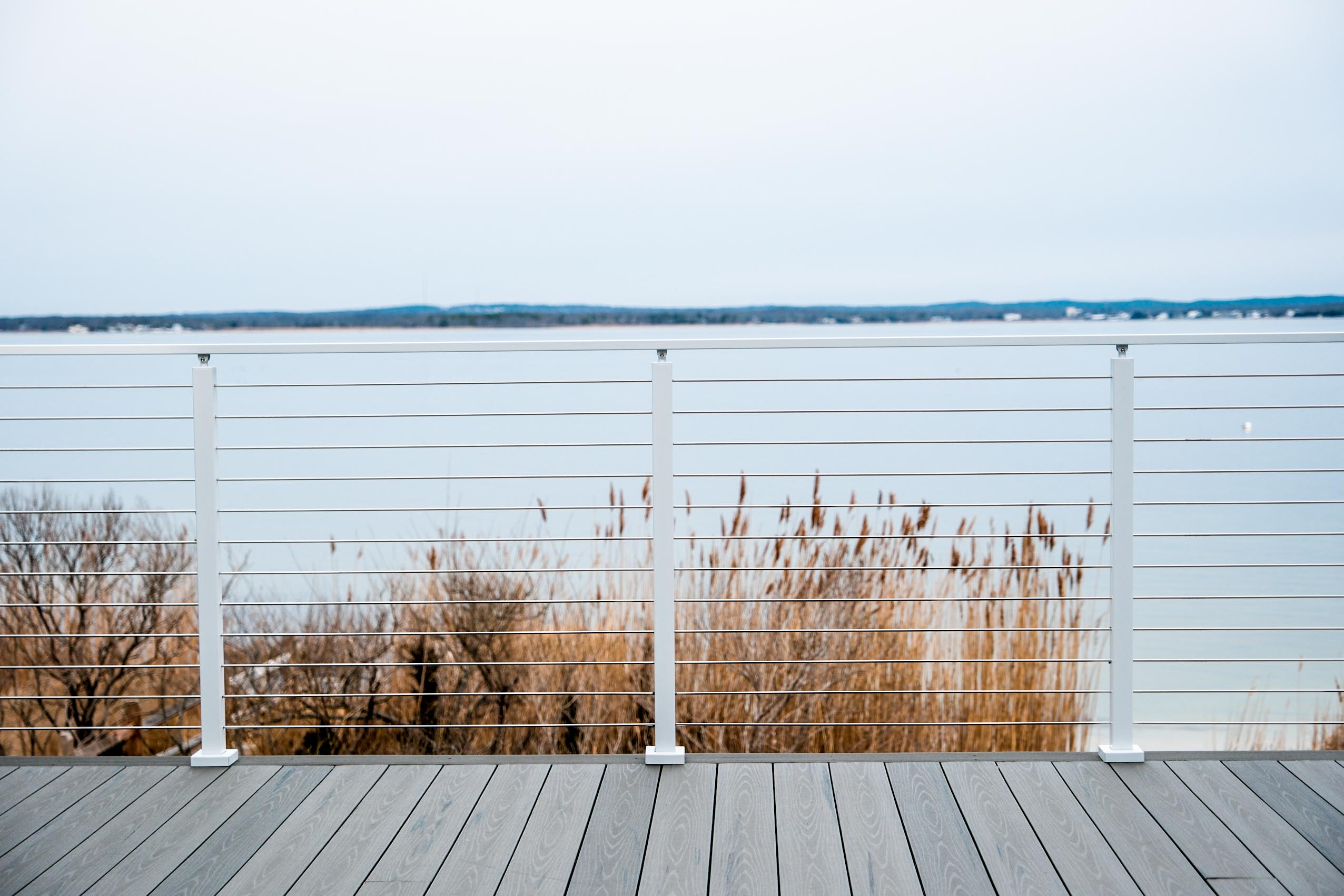 White cable railing on a coastal deck White powder-coated cable railing system on a cold, coastal deck