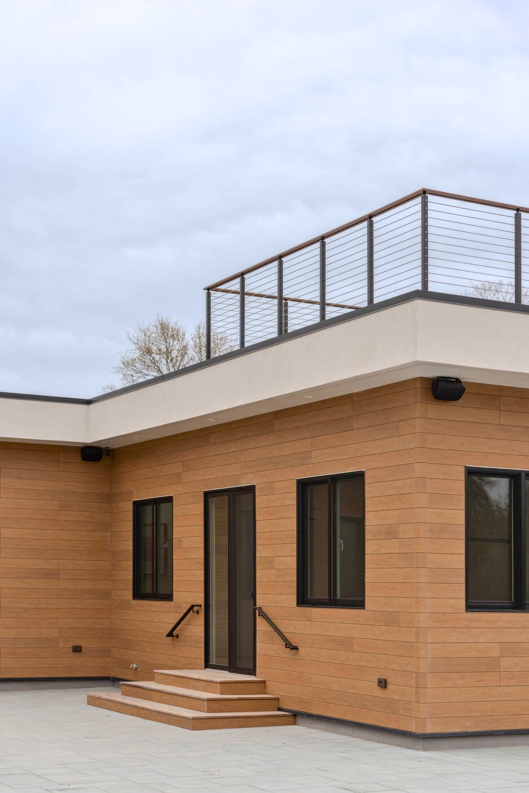 The front left corner of the house is shown with rod railing installed above.