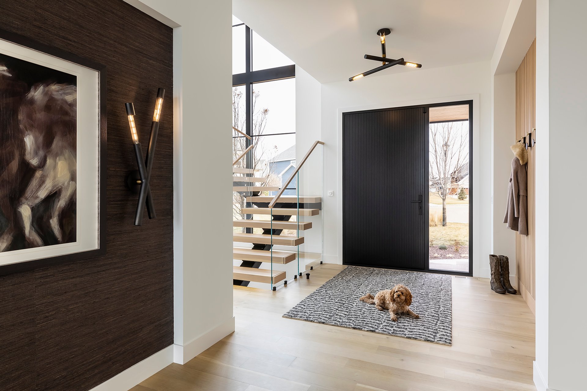 A shot in a hallway looking towards the front door, with the stairs to the left