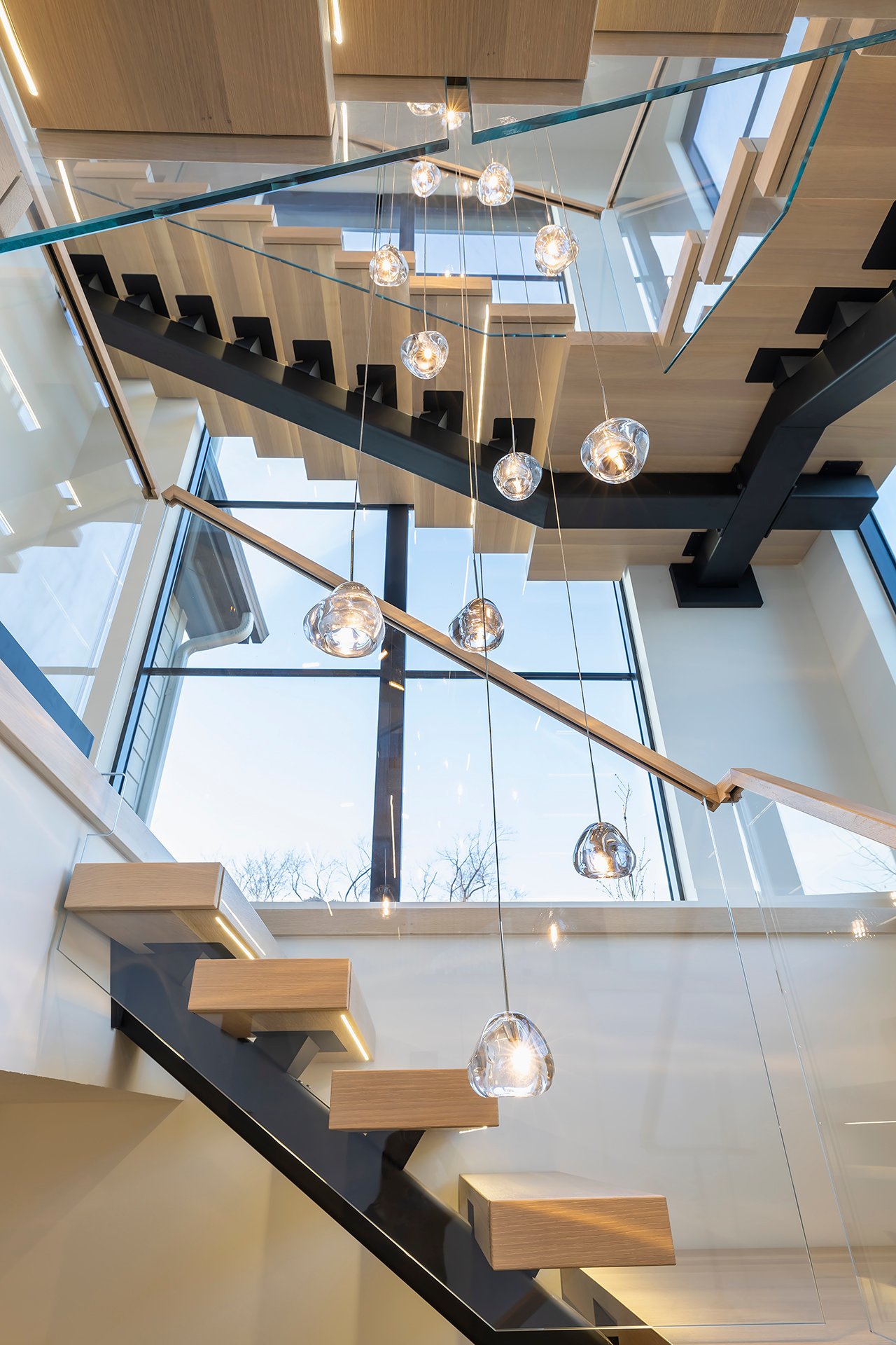 Looking up through the middle of the staircase with the chandelier in the center