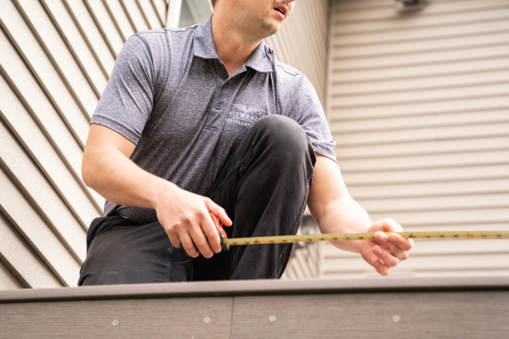 A Viewrail installer measures a deck space for railing