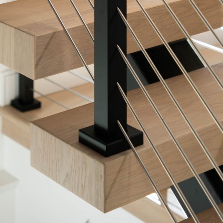 Close up of signature railing with stainless rods installed on a FLIGHT Mono stair system