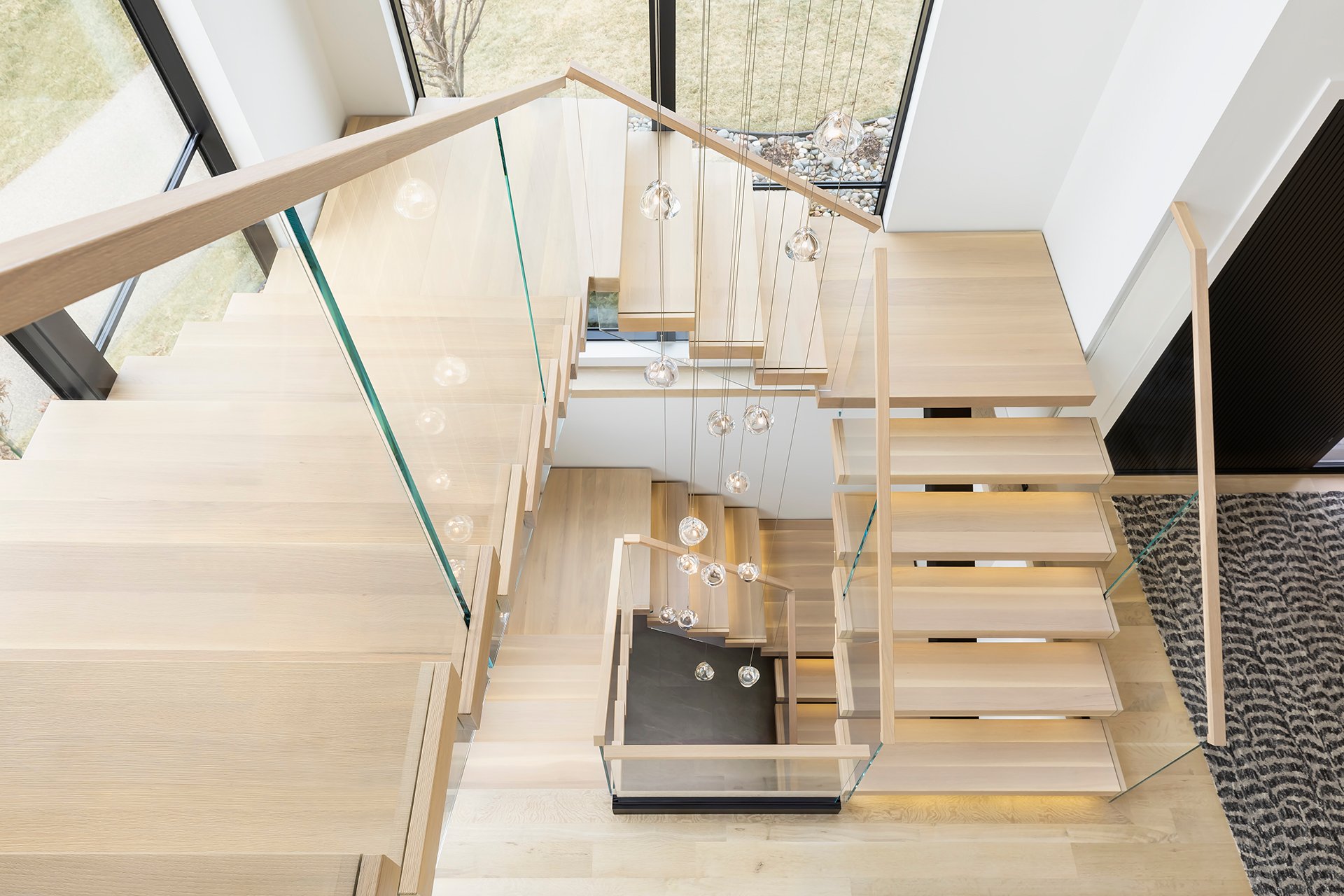 A top-down shot of a two-story, U-shaped FLIGHT Mono staircase in a corner stairwell with floor to ceiling windows.
