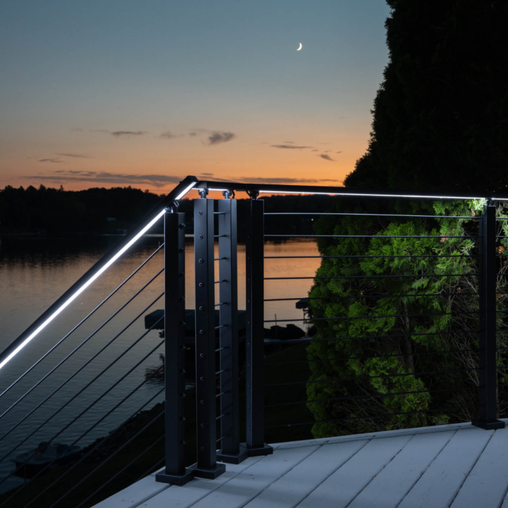 Signature cable railing at night illuminated by integrated railing LEDs