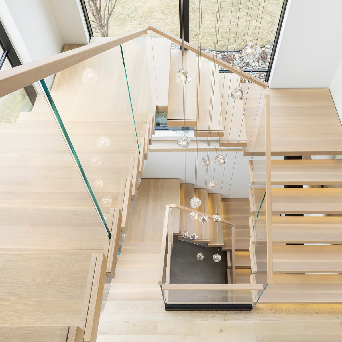 A multi-level FLIGHT Mono staircase with Vedera glass railing.