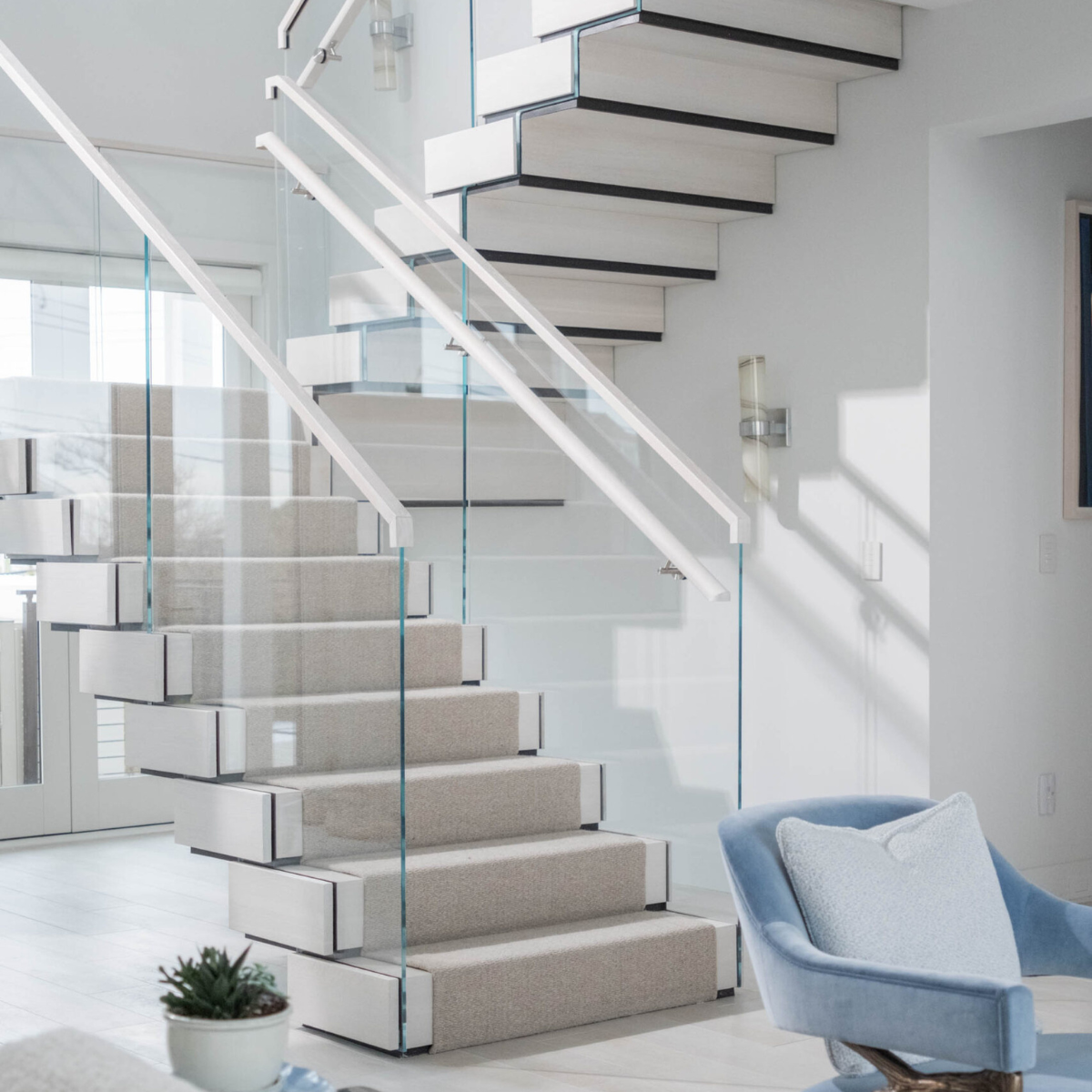 A multi-level FLIGHT Stack staircase with glass railing and carpeted treads.