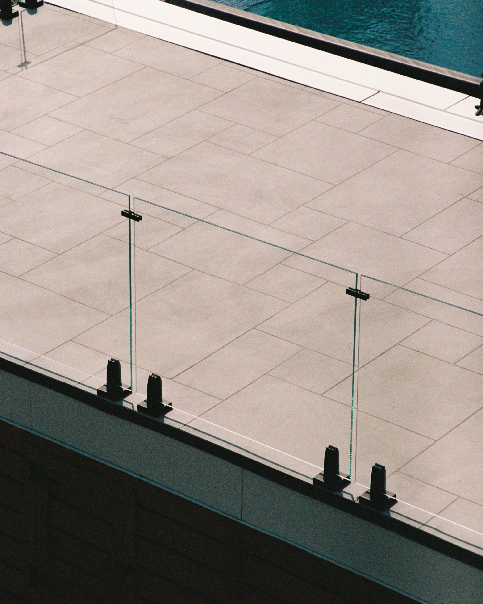 A silhouetted Talon Spigot system fences in a large pool area.