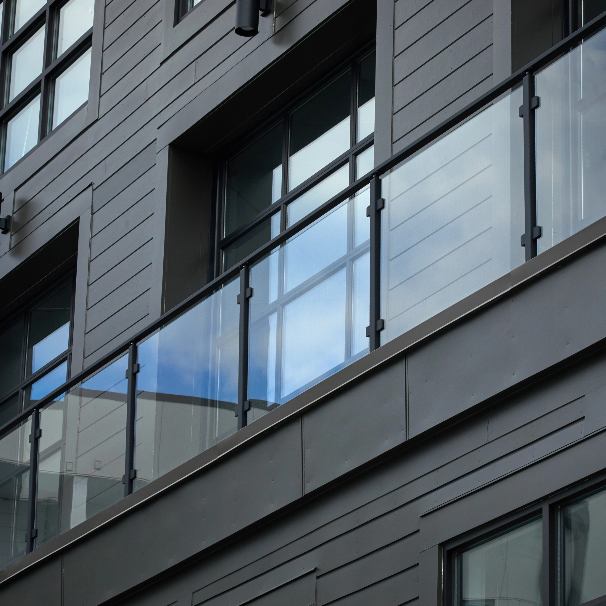 Glass post on a commercial building balcony with black posts.