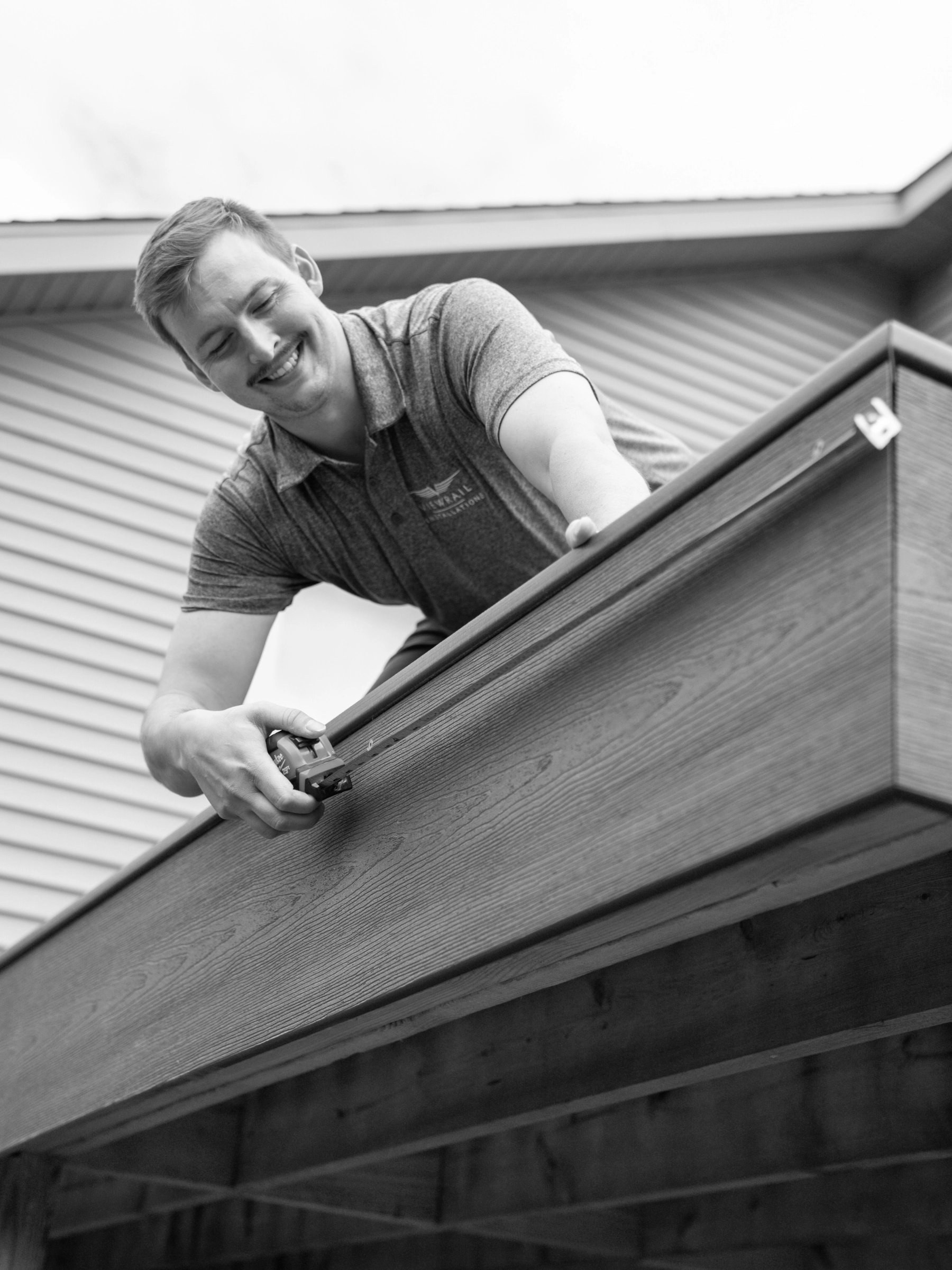 A Certified Installer taking deck measurements.